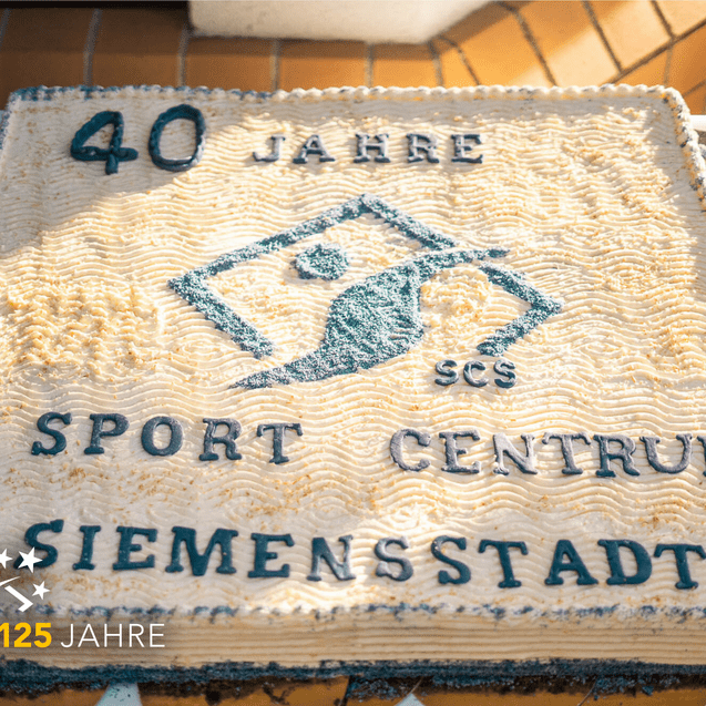 Torte zum 40-jährigen Jubiläum des Sport Centrums Siemensstadt mit Schriftzug und Logo in cremefarbener und blauer Dekoration.