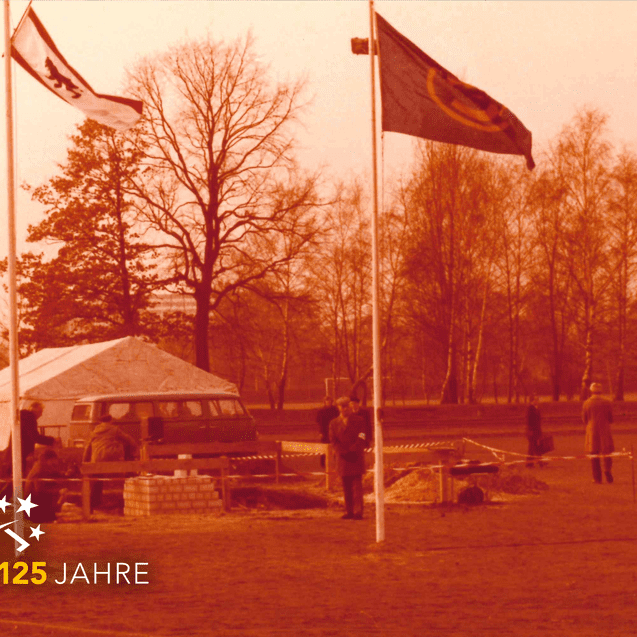 Historische Aufnahme eines Festes mit Fahnen, einem Zelt und Besuchern auf einem freien Platz im Herbst.
