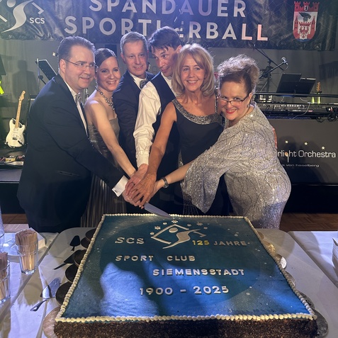 Sechs Personen stehen um eine festliche Torte mit dem Logo des Sport Clubs Siemensstadt zum 125-j&auml;hrigen Jubil&auml;um.
