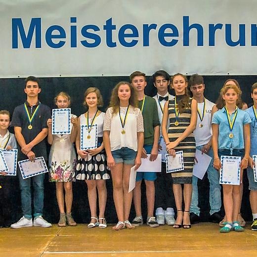 Gruppenszene der Meisterehrung 2016 mit Kindern und Jugendlichen in festlicher Kleidung, Medaillen und Urkunden.