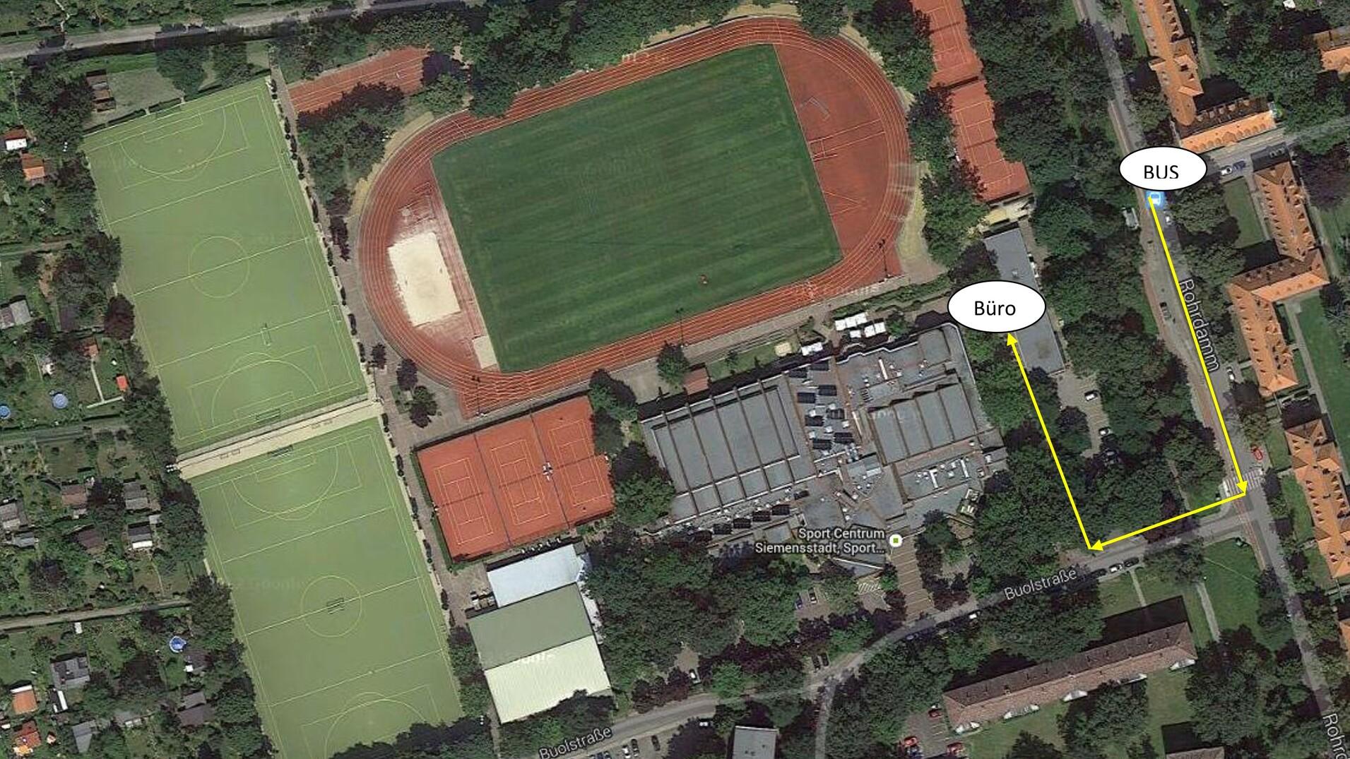 Luftbild einer Sportanlage mit Fußballplätzen, Laufbahn und Weg zum Büro, gekennzeichnet durch gelbe Pfeile.