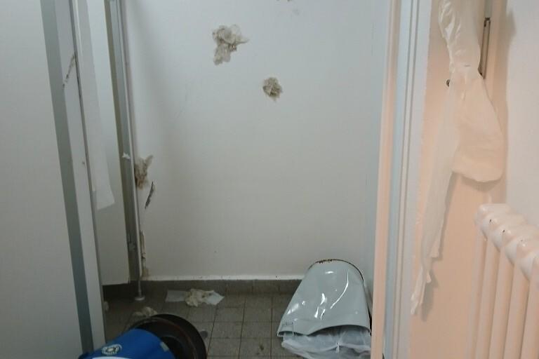 Blick in einen ungepflegten Raum mit Fussball-Werbeaufsteller, abgerissenem Papier und Schmutz auf dem Boden.