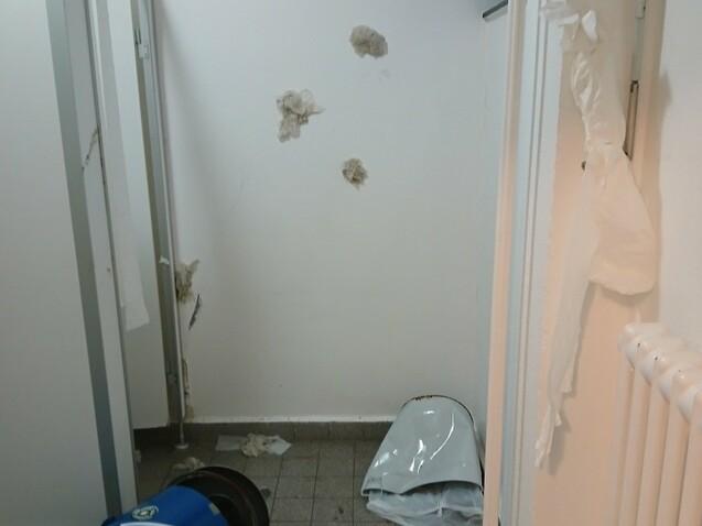 Blick in einen ungepflegten Raum mit Fussball-Werbeaufsteller, abgerissenem Papier und Schmutz auf dem Boden.