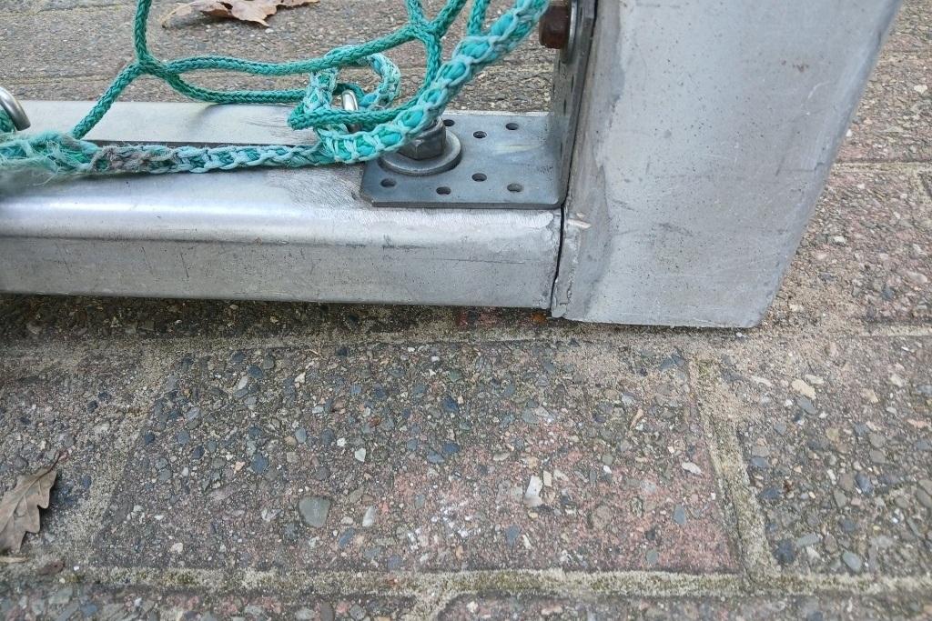 Detailaufnahme der Unterseite eines Tischtennis-Tisches mit Montageschraube und gr&uuml;nem Seil.