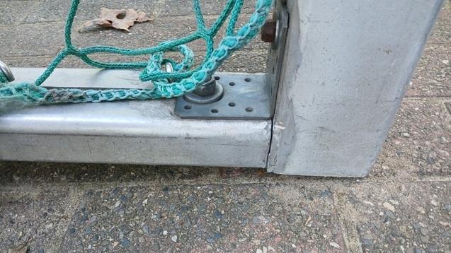 Detailaufnahme der Unterseite eines Tischtennis-Tisches mit Montageschraube und grünem Seil.