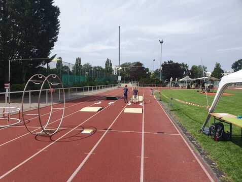 Leere Laufbahn mit Hindernissen und Aufbauten, Sportler bereiten sich auf einen Wettkampf vor.