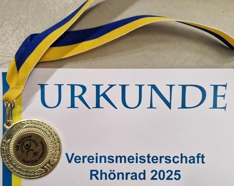 Goldmedaille mit blau-gelbem Band auf einer Urkunde f&uuml;r die Vereinsmeisterschaft im Rh&ouml;nrad 2025.