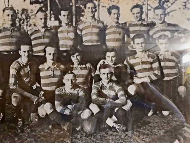 Gruppenfoto von 15 Spielern in gestreiften Trikots, die auf einem Fußballfeld posieren.
