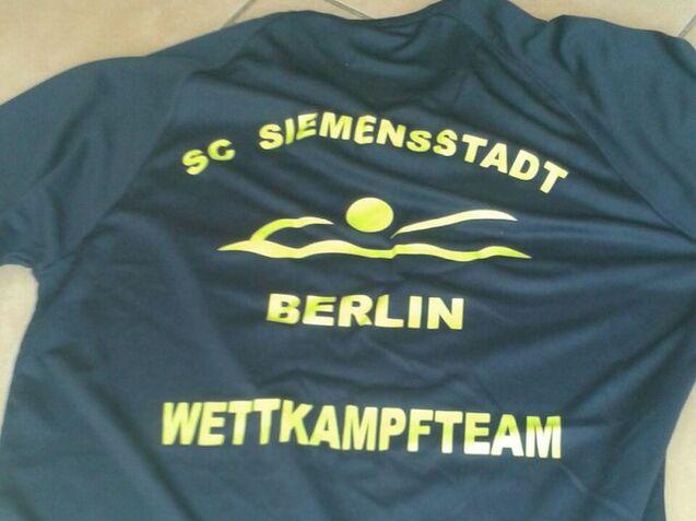 Rückansicht eines Sportshirts in Blau, bedruckt mit „SC SIEMENSSSTADT BERLIN WETTKAMPFTEAM“ in gelben Buchstaben.