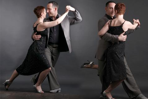 Tanzpaar in eleganter Kleidung tanzt eng umschlungen, auf grauem Hintergrund, ausdrucksvoll und harmonisch.