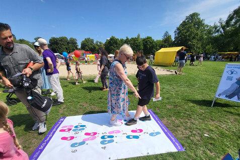 2 Personen, eine Frau, ein Junge, üben auf der Bodenplane die Tango Grund Schritte - Südparkfest Spandau