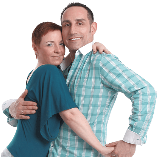 Ein Paar umarmt sich lächelnd, der Mann trägt ein kariertes Hemd, die Frau ein türkisfarbenes Oberteil. Hintergrund weiß.