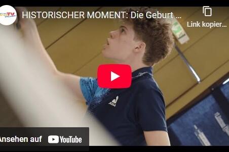 Junger Tischtennisspieler trainiert konzentriert an einer Tischtennisplatte in einer Sporthalle.