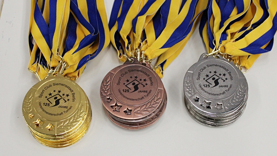Drei Medaillen in Gold, Silber und Bronze, jeweils mit einem blauen und gelben Band, für den Sport Club Siemensstadt Berlin.