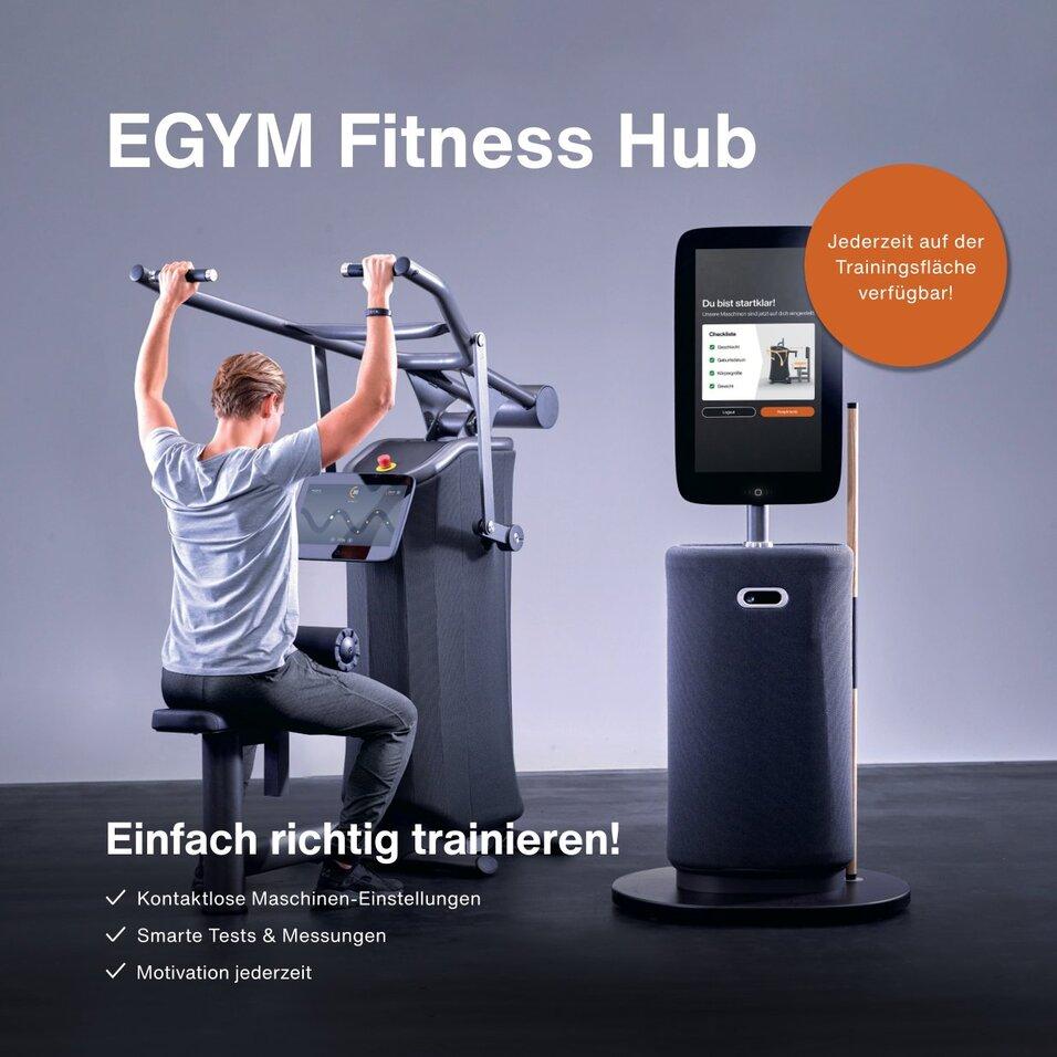 Mann trainiert an einem EGYM-Fitnessgerät mit digitalem Monitor in modernem Fitnessstudio-Umfeld.