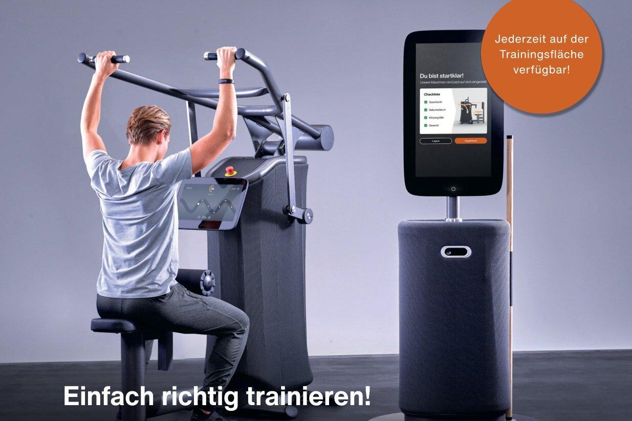 Mann trainiert an einem EGYM-Fitnessger&auml;t mit digitalem Monitor in modernem Fitnessstudio-Umfeld.