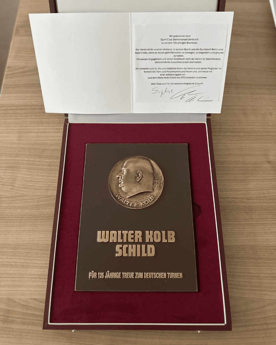 Bronzeplakette mit Inschrift „Walter Kolb Schild“ zur Ehrung für 125 Jahre Treue zum Deutschen Turnen in einer Präsentationsbox.
