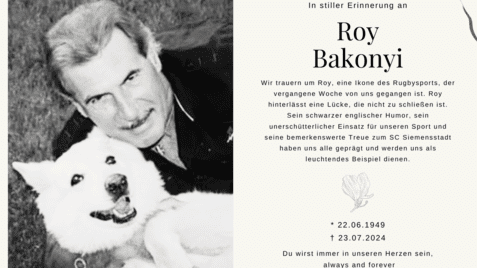 Porträt eines Mannes mit grauem Haar, der lächelnd einen weißen Hund auf dem Schoß hält. Erinnerungsanzeige für Roy Bakonyi.