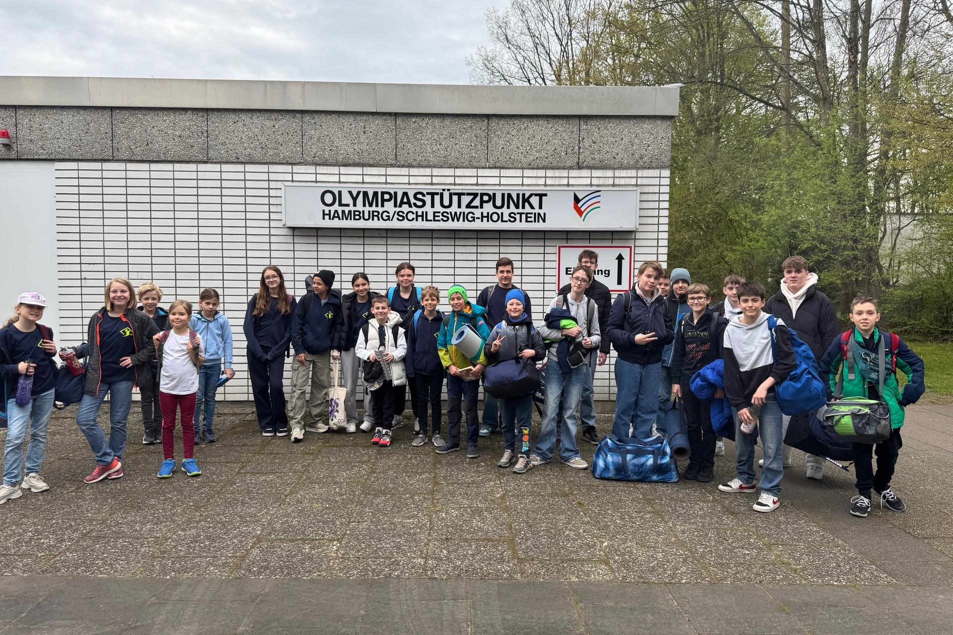 Gruppe von Kindern und Jugendlichen vor dem Olympiastützpunkt Hamburg/Schleswig-Holstein, bereit für eine Veranstaltung.
