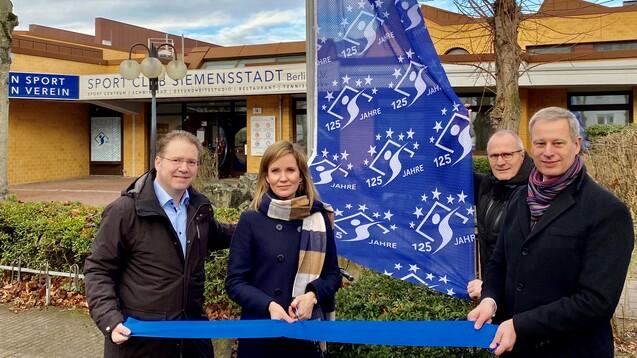 Eröffnung des 125-jährigen Jubiläums des Sport Club Siemensstadt mit einer Blaupause und Fahne.
