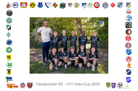 Gruppierung von zehn jungen Fu&szlig;ballspielern in schwarzer Teamkleidung, posierend mit Trainer in einem Park.