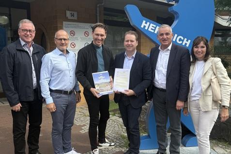 Gruppenfoto von 6 Personen vor dem Eingang eines Schwimmbads