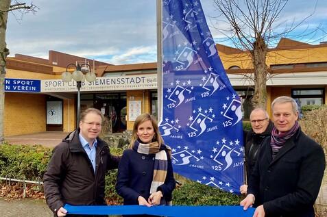 Er&ouml;ffnung des 125-j&auml;hrigen Jubil&auml;ums des Sport Club Siemensstadt mit einer Blaupause und Fahne.