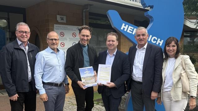 Gruppenfoto von 6 Personen vor dem Eingang eines Schwimmbads