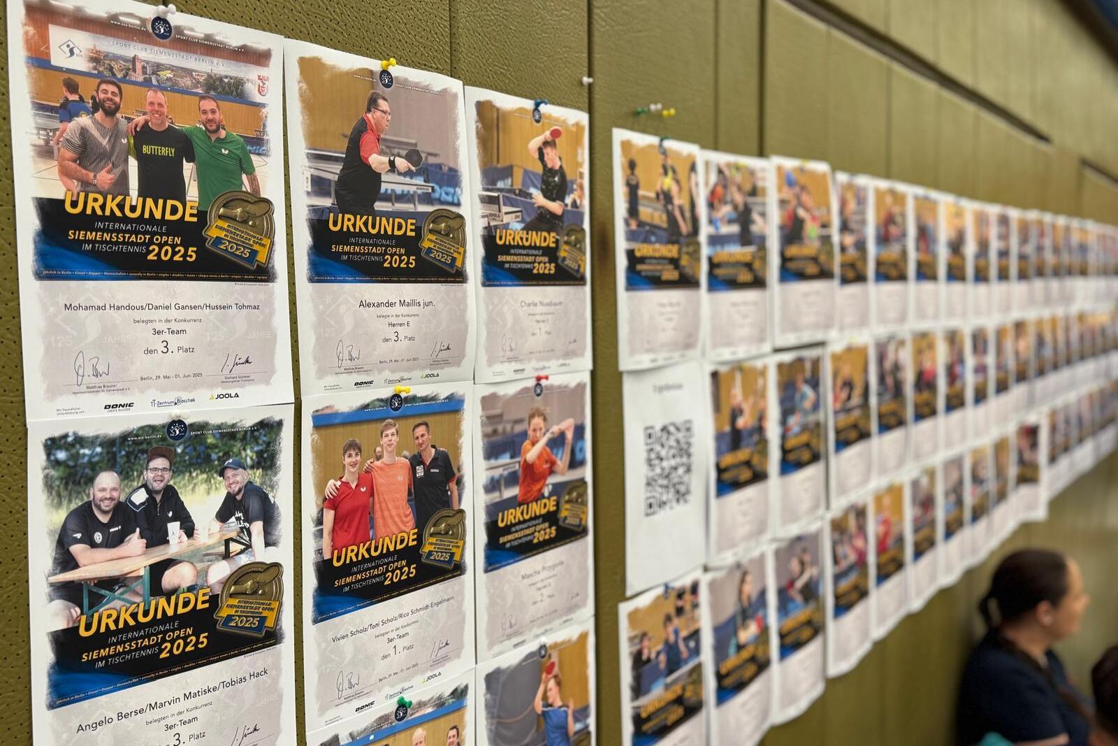 Wand mit mehreren Urkunden des Tischtennisturniers &bdquo;Siemenstadt Open 2025&ldquo;; Teilnehmer und Platzierungen sichtbar.