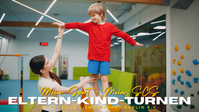 Mutter hebt lächelnd ihren Sohn in rotem Shirt während des Eltern-Kind-Turnens in einem Sportclub.