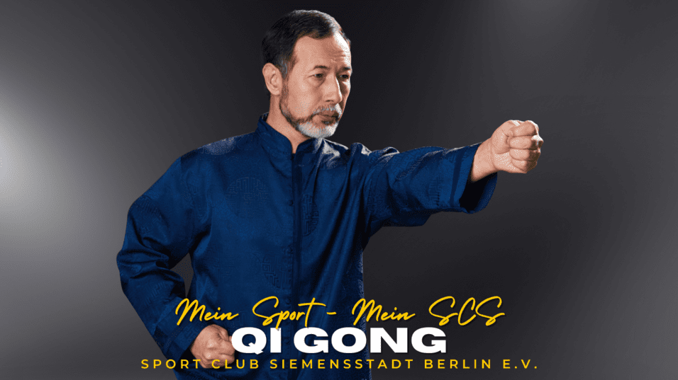 Mann in blauer Qi Gong-Tunica vollzieht eine Bewegung mit erhobenem Arm und geballter Faust vor neutralem Hintergrund.