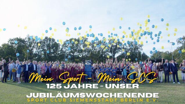 Gruppenfoto zum 125-jährigen Jubiläum des Sport Clubs Siemensstadt Berlin mit bunten Luftballons und fröhlichen Feiernden.