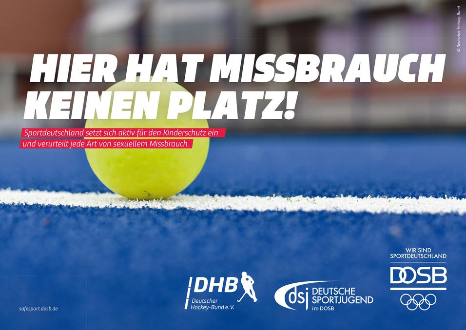 Gelber Hockeyball auf blauem Kunstrasen; Schrift: „Hier hat Missbrauch keinen Platz!“